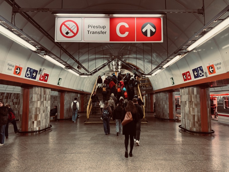 a group of people walking up stairs in a subway