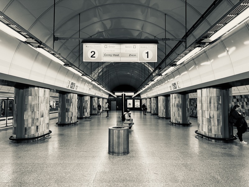 a person sitting on a bench in a subway station
