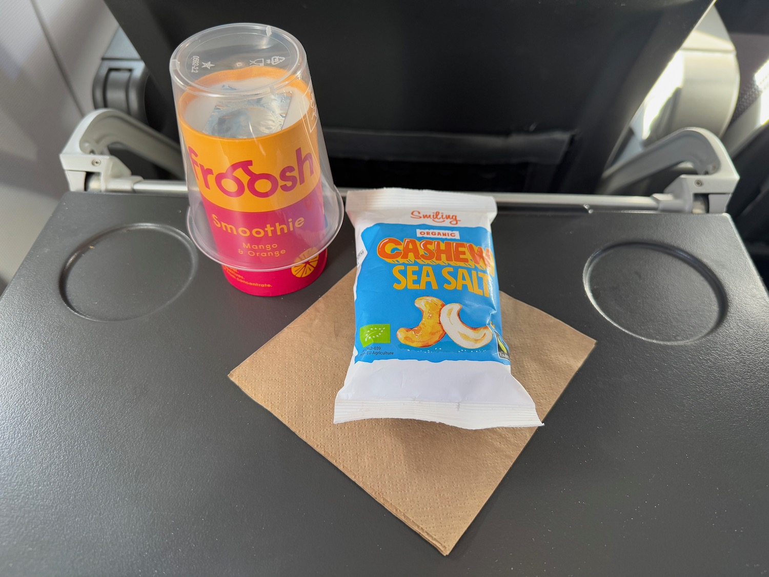 a plastic cup and a bag of food on a napkin