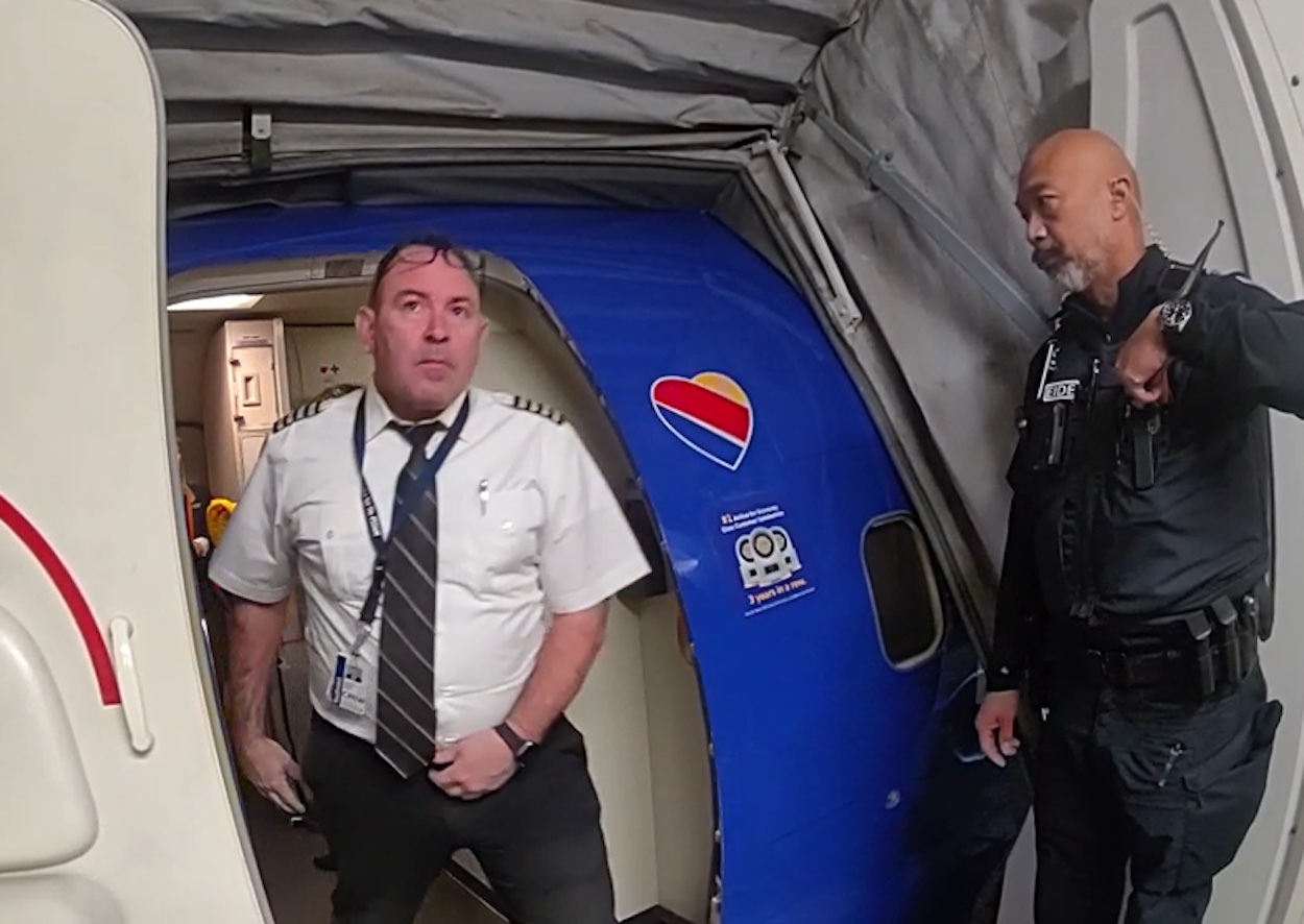 a man standing in a blue tent next to a man in a white shirt