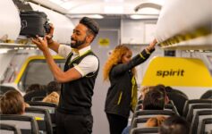 a man holding a luggage case in an airplane