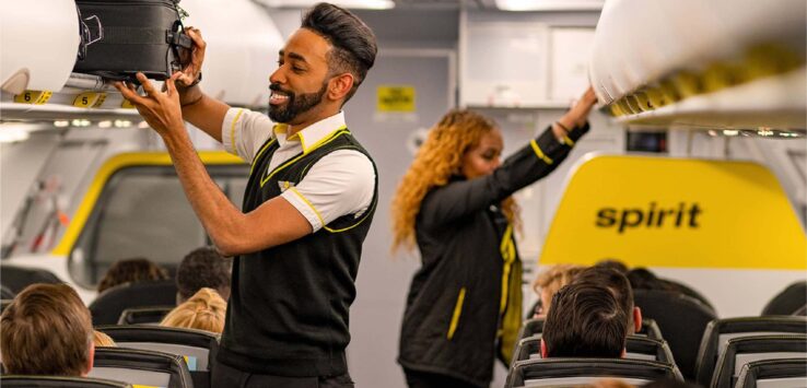 a man holding a luggage case in an airplane