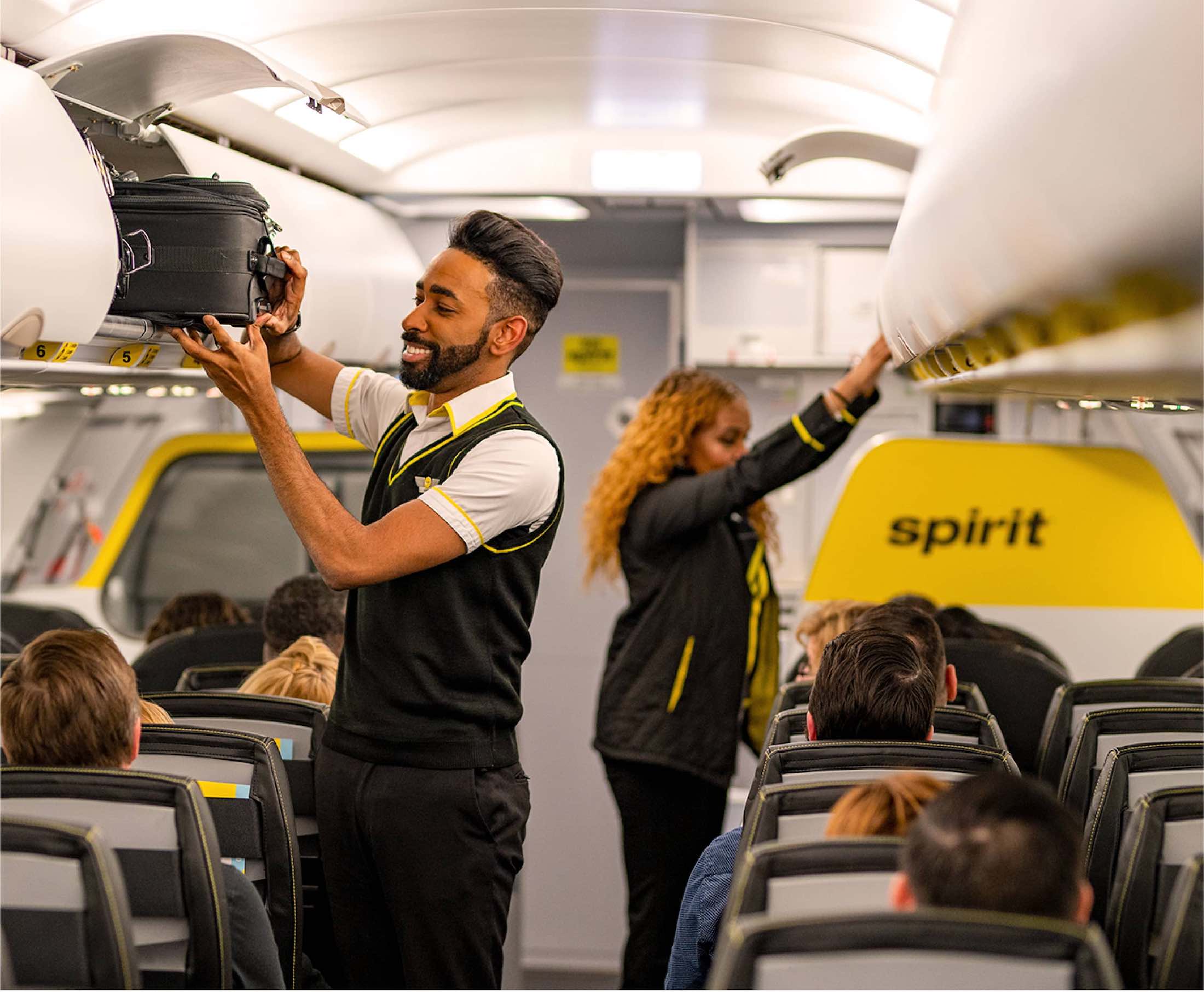a man holding a luggage case in an airplane