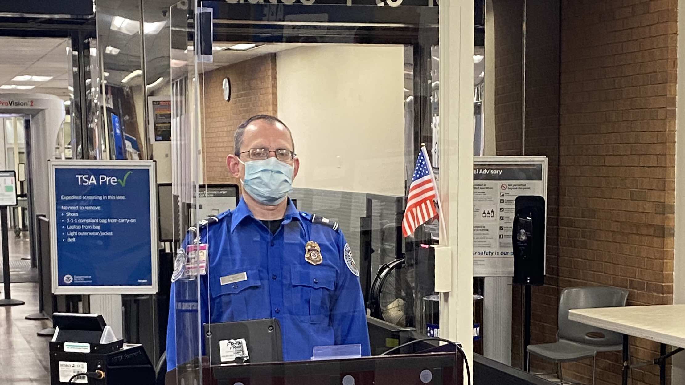a man wearing a face mask standing in a booth