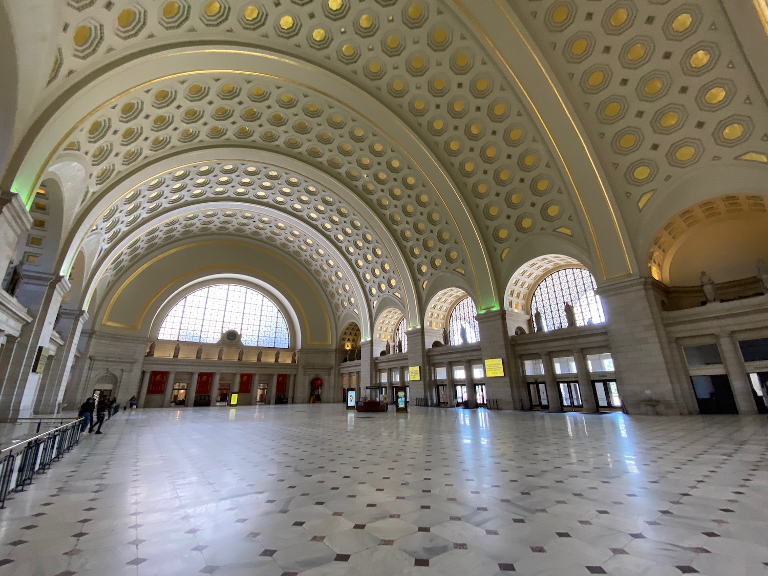 a large white and gold building with arched ceiling with Union Station in the background