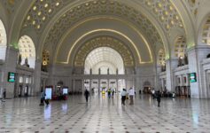 a large white building with many people walking around with Union Station in the background