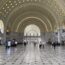 a large white building with many people walking around with Union Station in the background