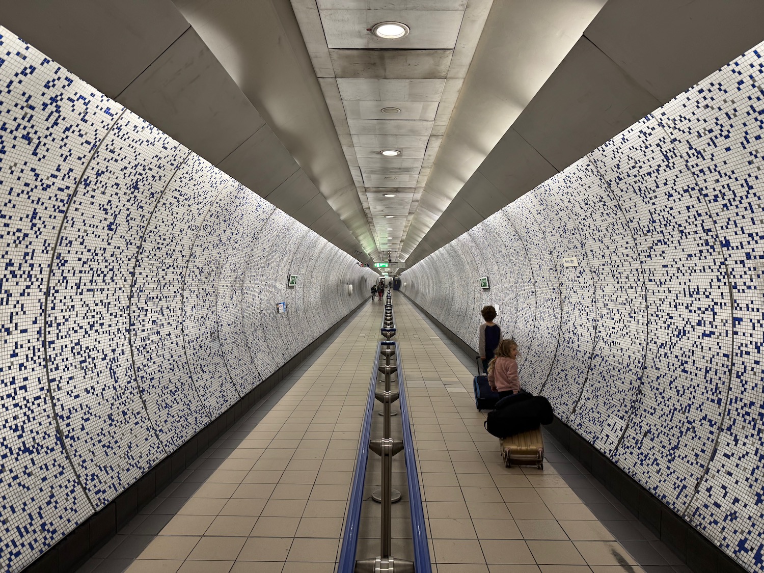 people in a tunnel with luggage