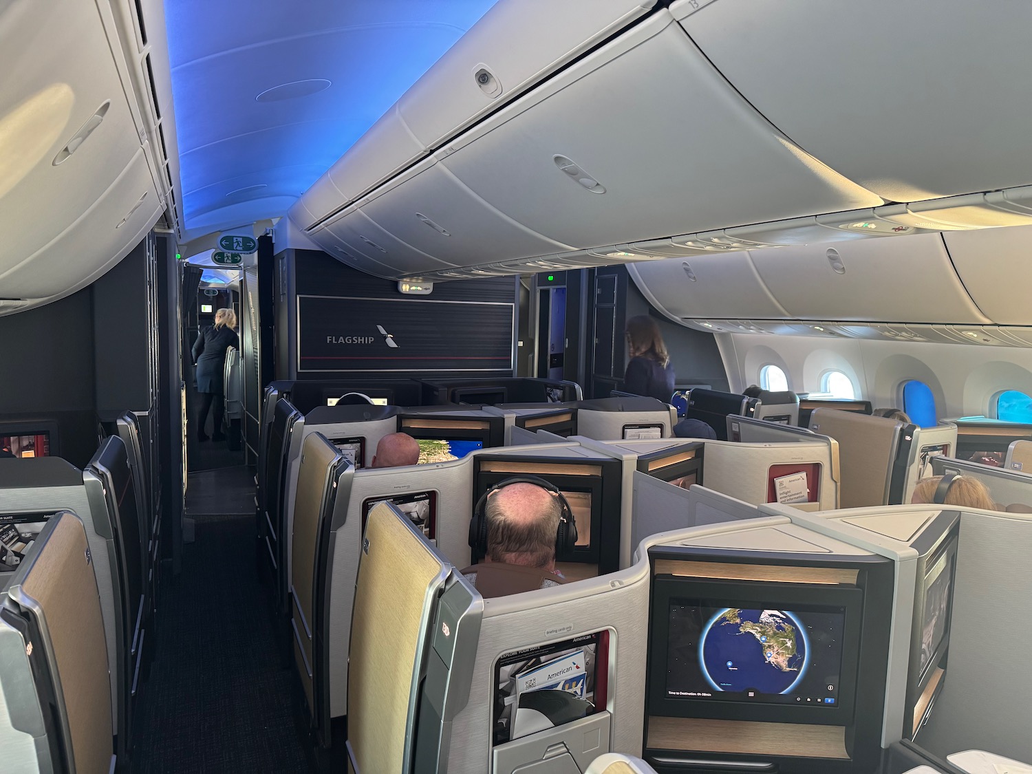 people sitting in an airplane with monitors