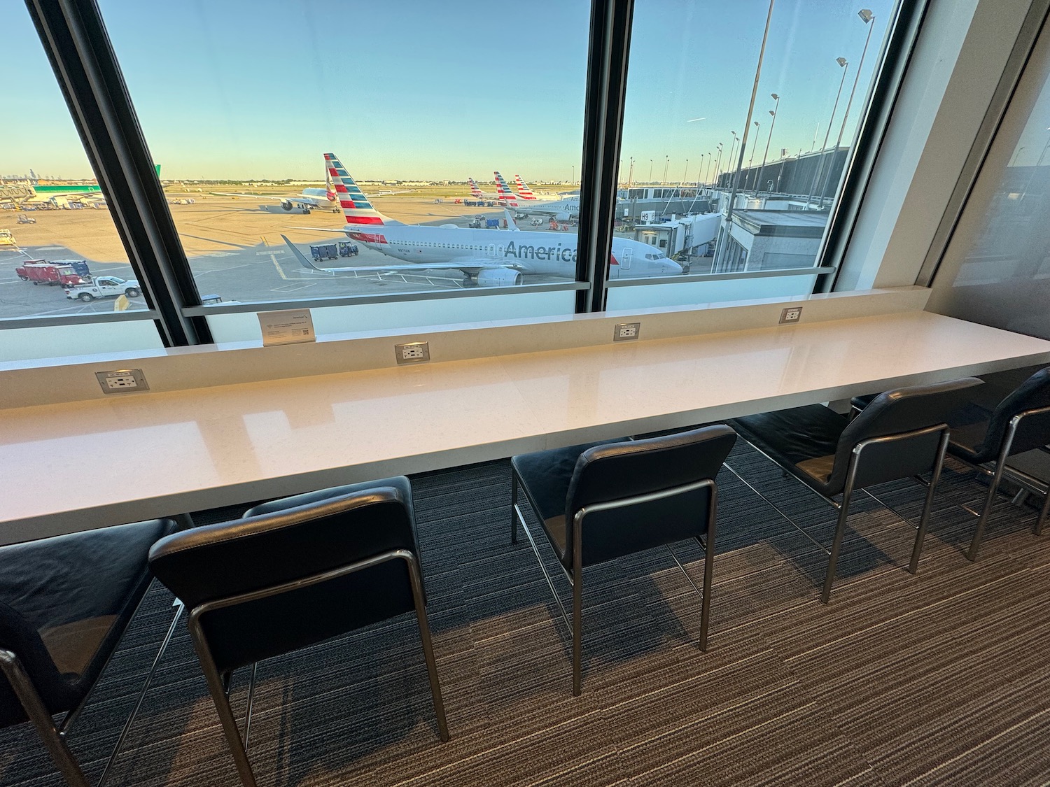 a long table with chairs and a plane in the background