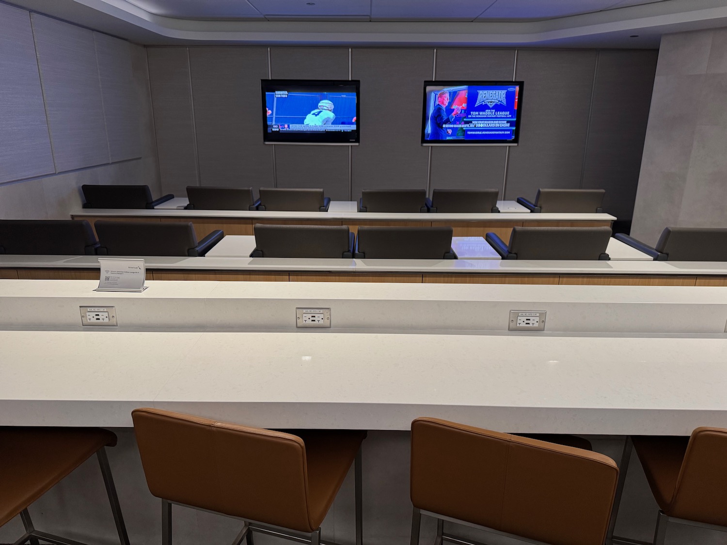 a room with a table and chairs and a television on the wall