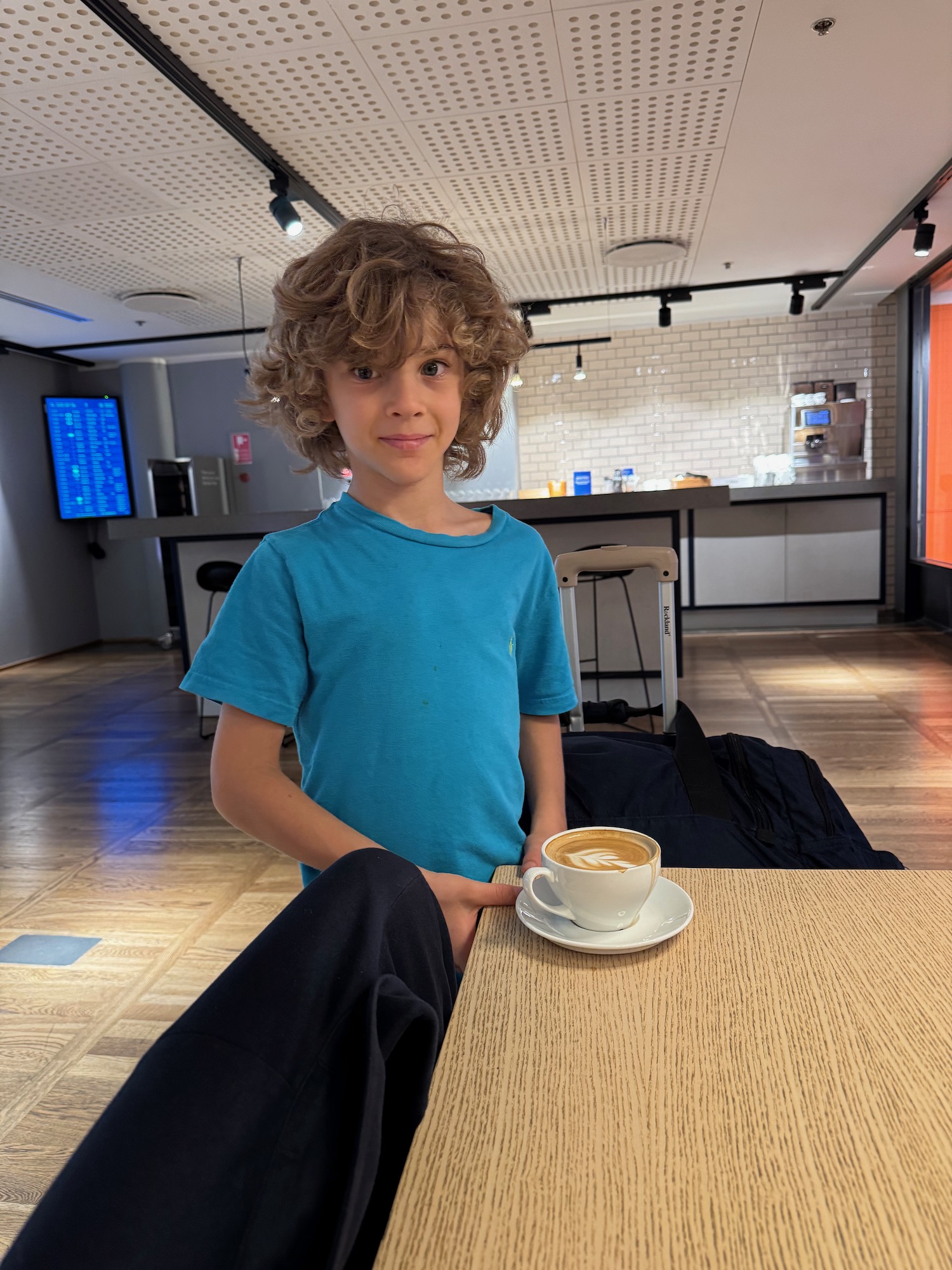 a boy holding a cup of coffee