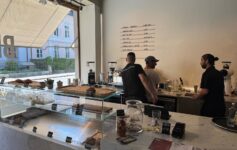 a group of men standing behind a counter in a coffee shop