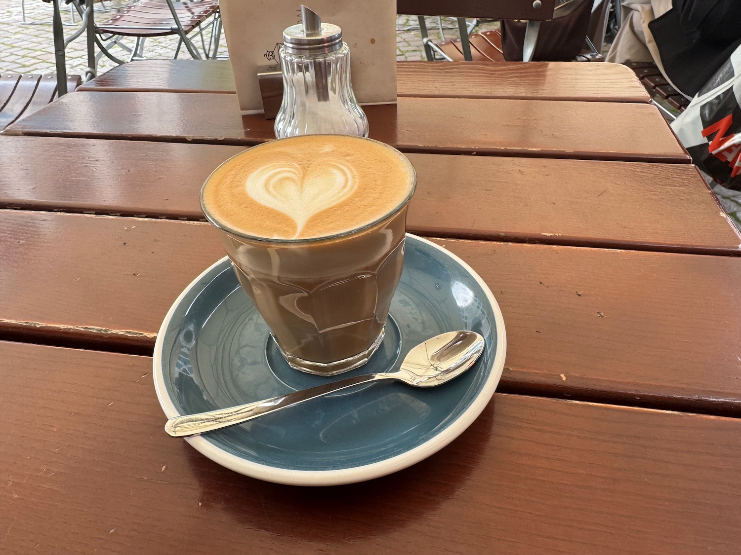 a cup of coffee on a plate with a spoon