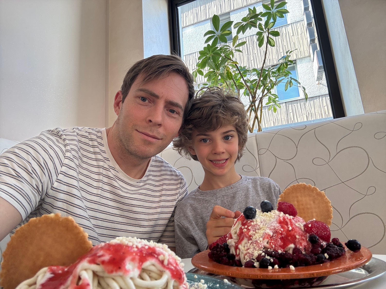 a man and boy sitting at a table with food