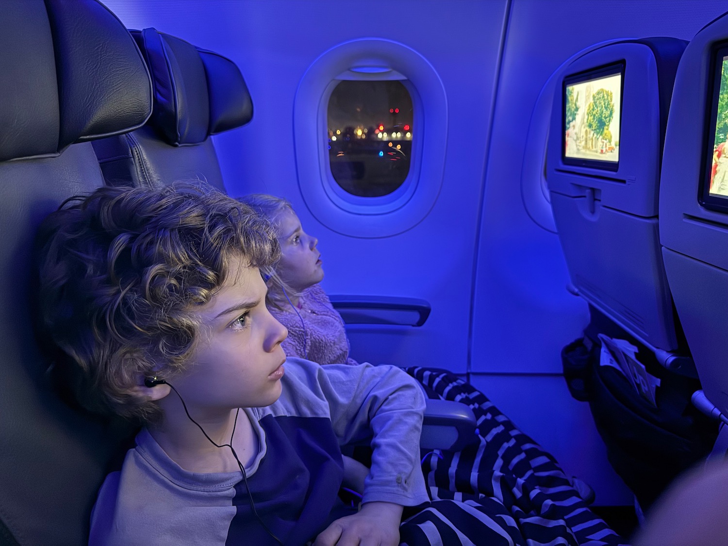 a boy and girl sitting in an airplane