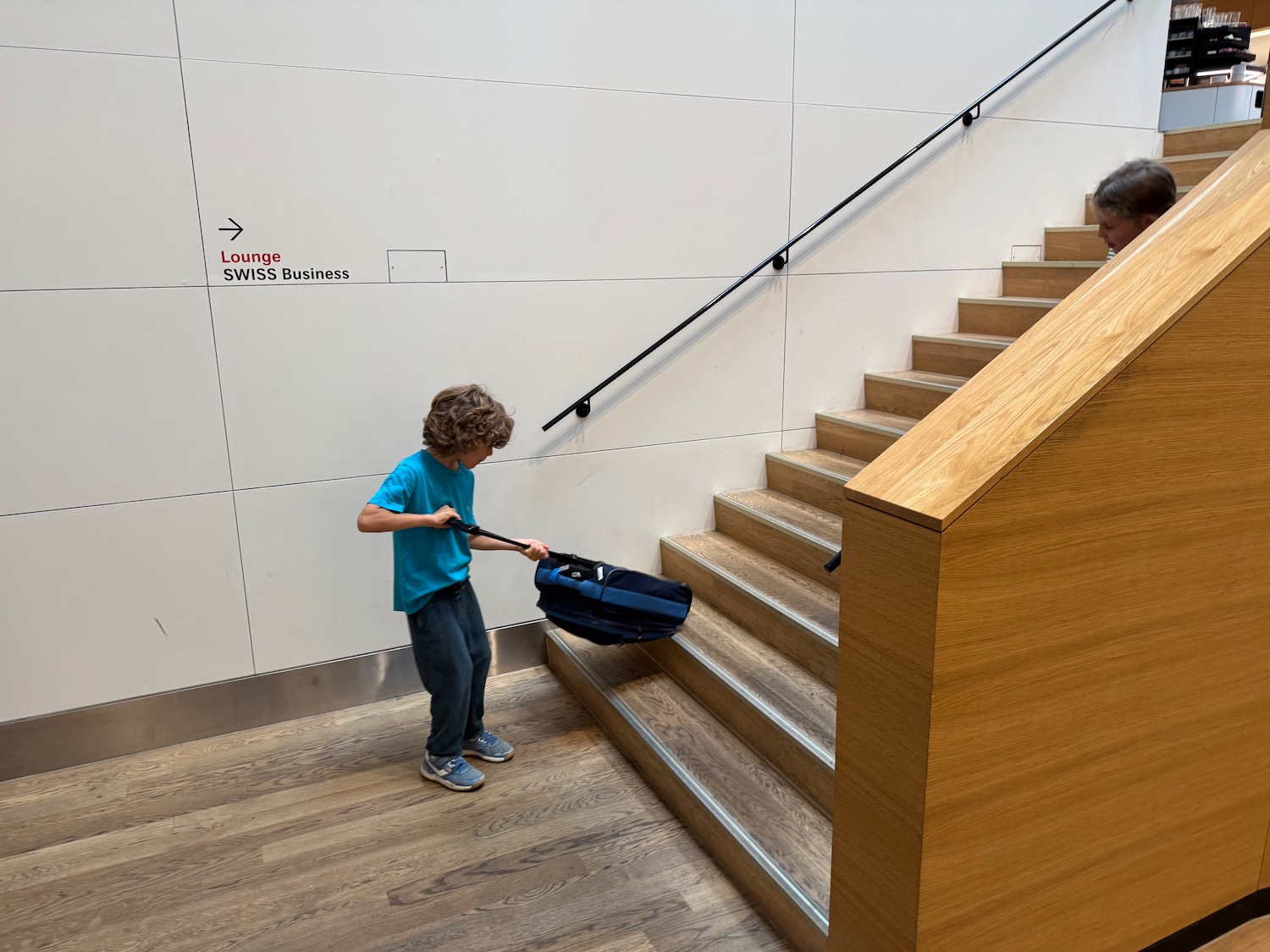 a child pulling a suitcase up stairs