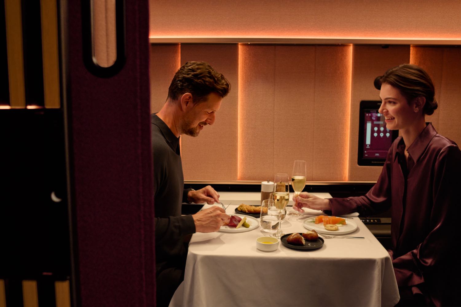 a group of people sitting at a table with food and drinks
