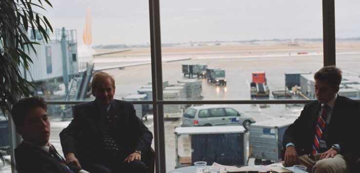 a group of men sitting in a room with a window
