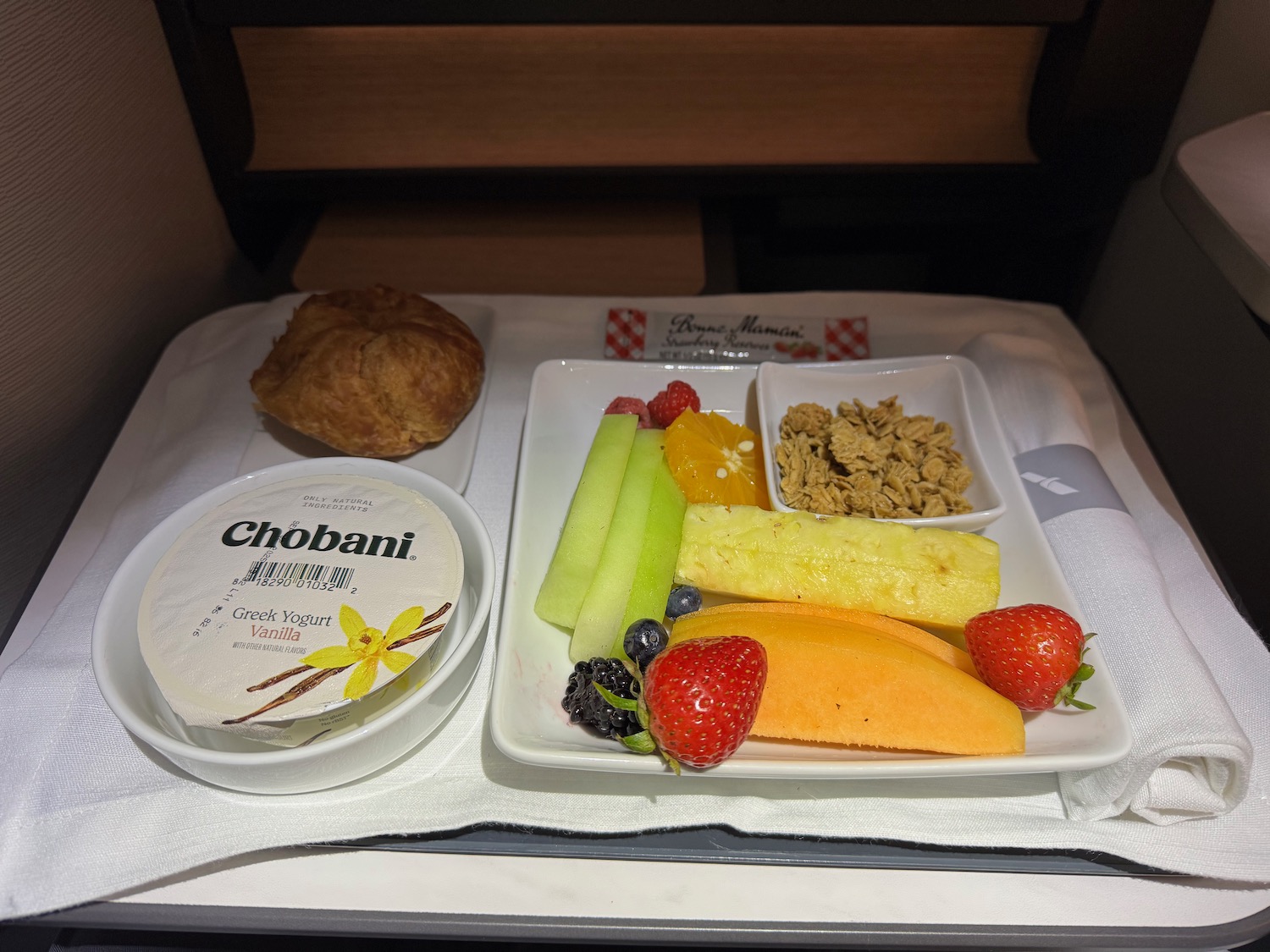 a plate of fruit and a bowl of cheese on a tray