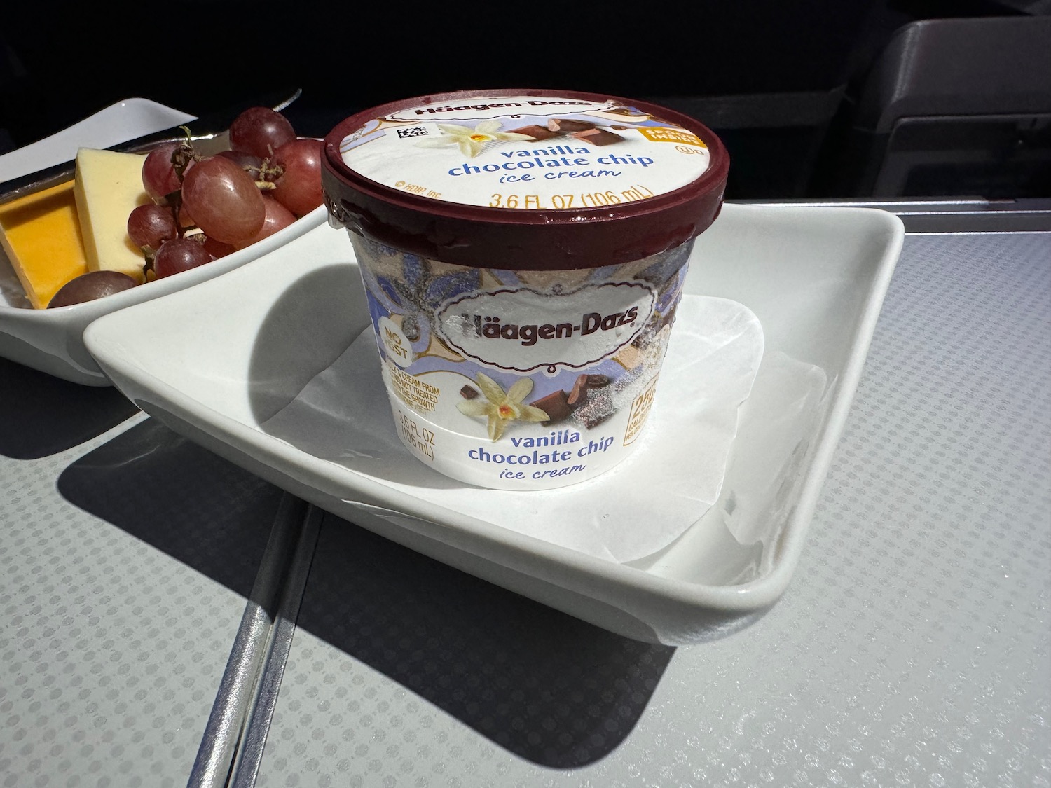 a bowl of ice cream with grapes on a table