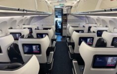 the inside of an airplane with seats and monitors