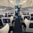 the inside of an airplane with seats and monitors