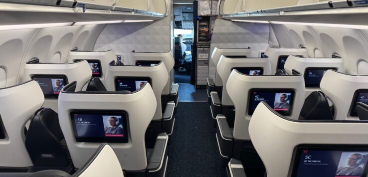 the inside of an airplane with seats and monitors