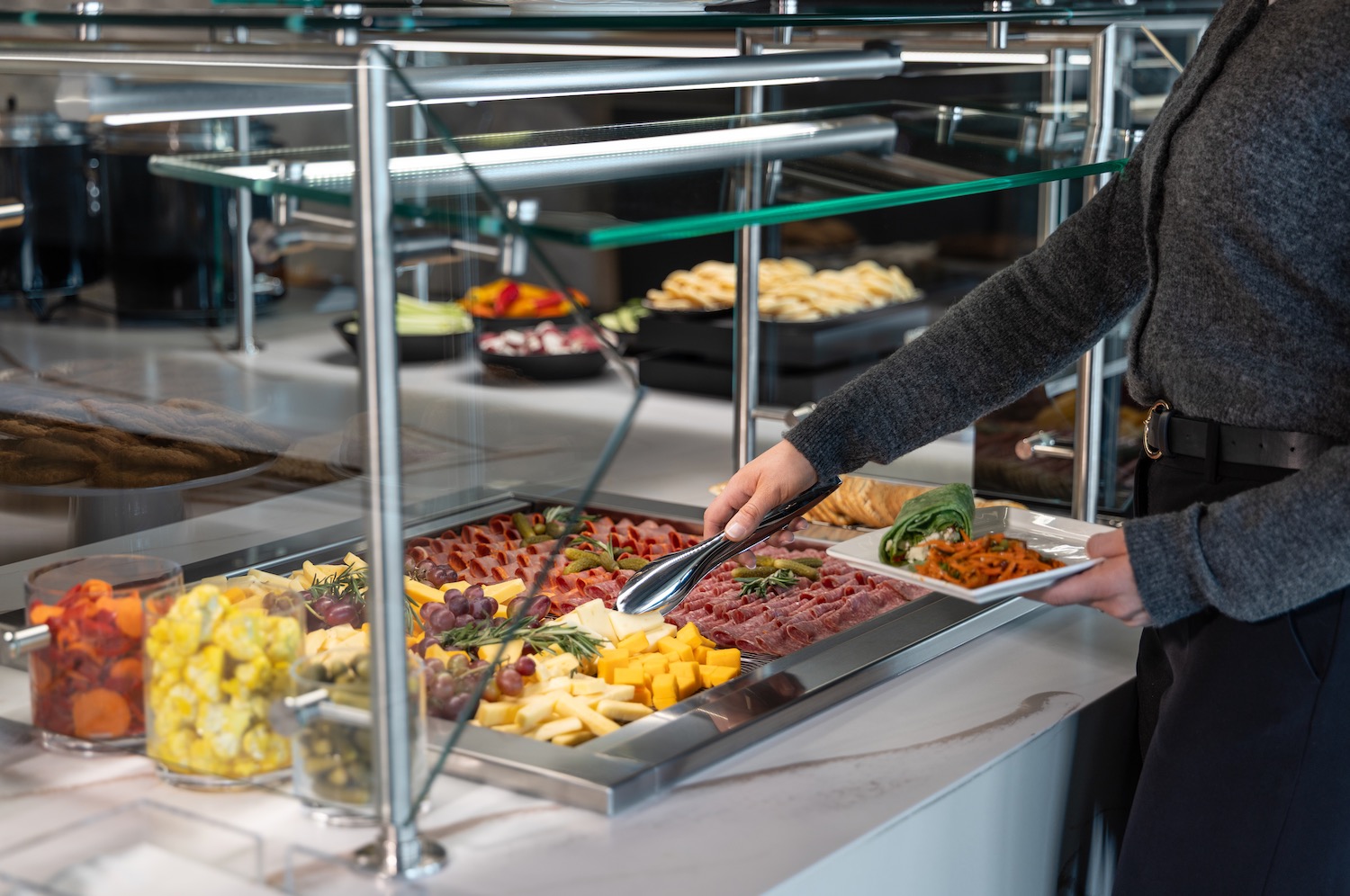 a person serving food in a buffet
