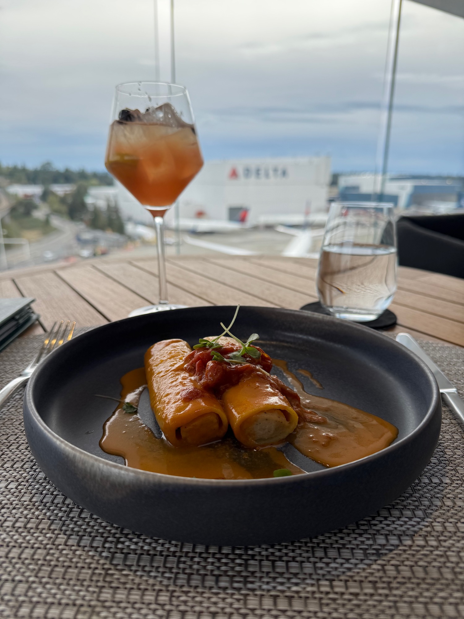 food on a plate with a drink in the background