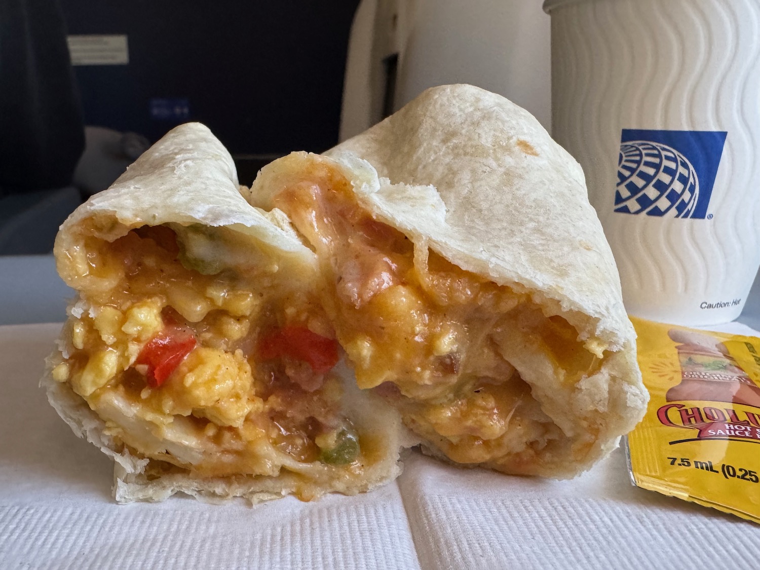 a burrito with eggs and cheese on a napkin