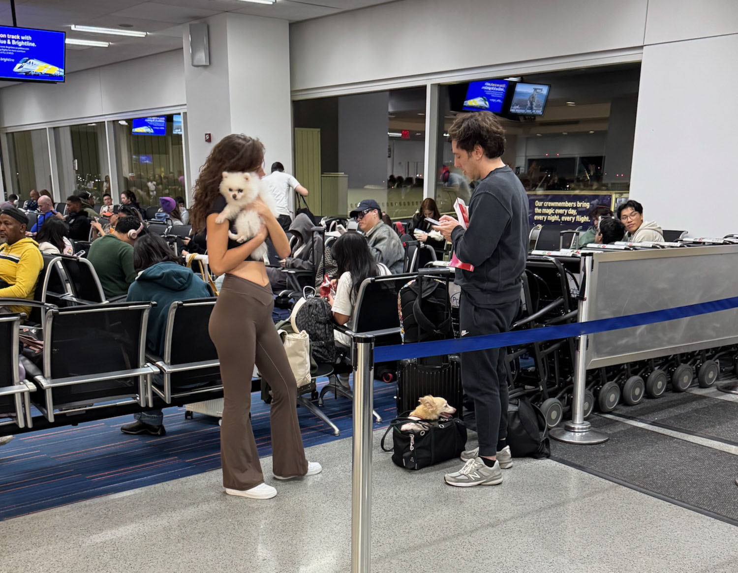 a woman holding a dog in a terminal