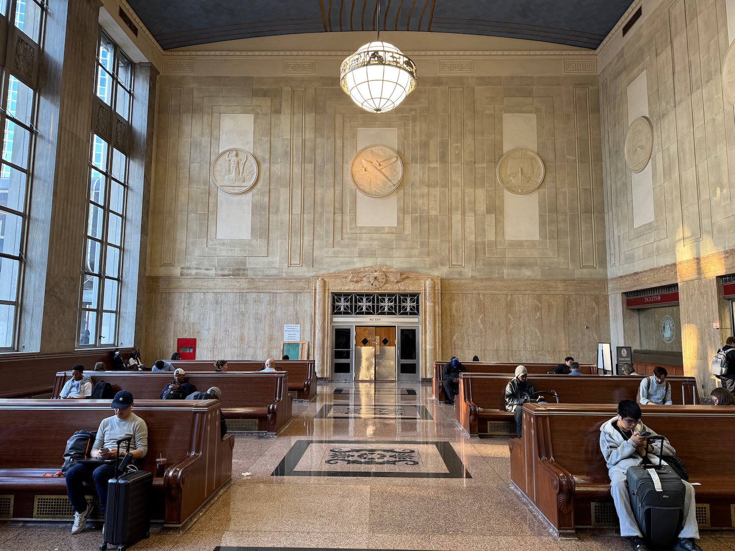 a large building with many benches and a large clock on the wall