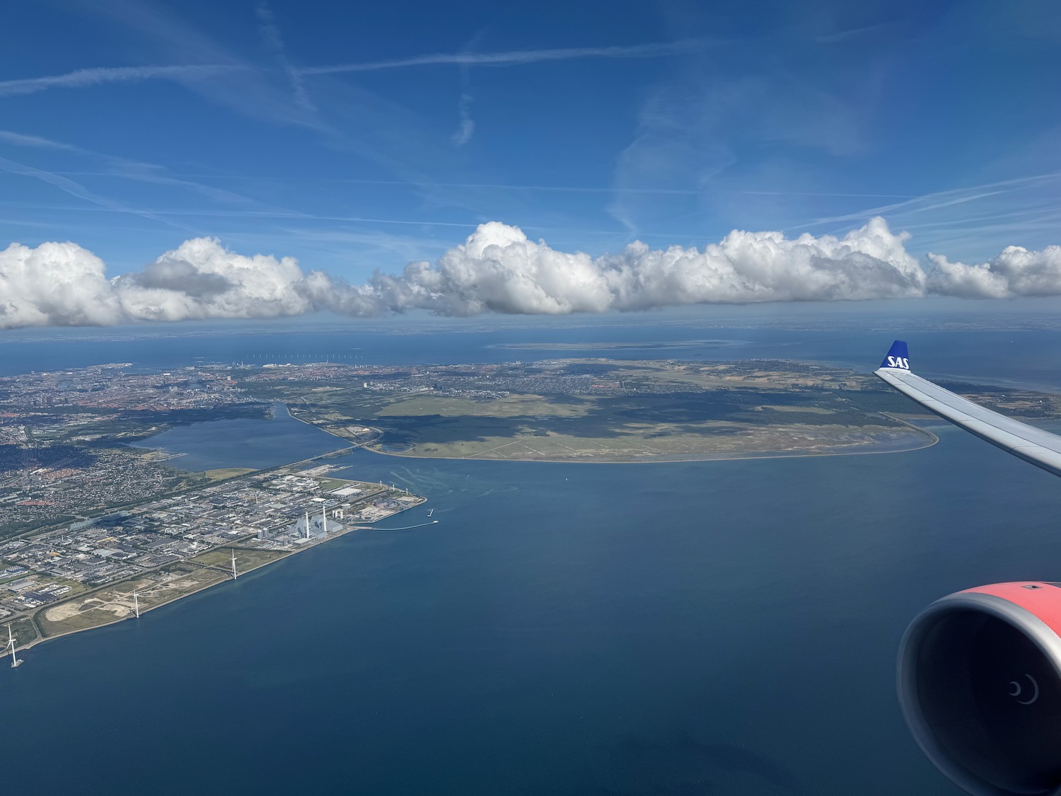 an airplane wing over water and land