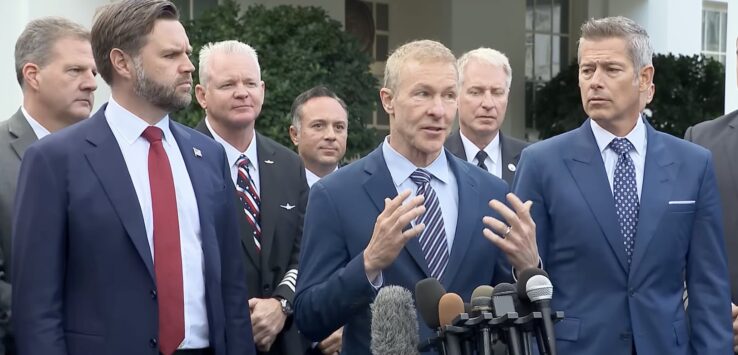 a group of men in suits standing in front of microphones