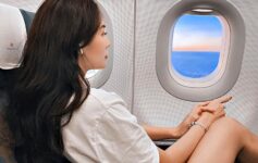 a woman sitting in an airplane looking out the window