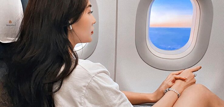 a woman sitting in an airplane looking out the window