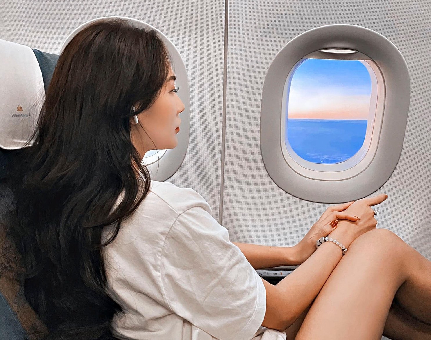 a woman sitting in an airplane looking out the window