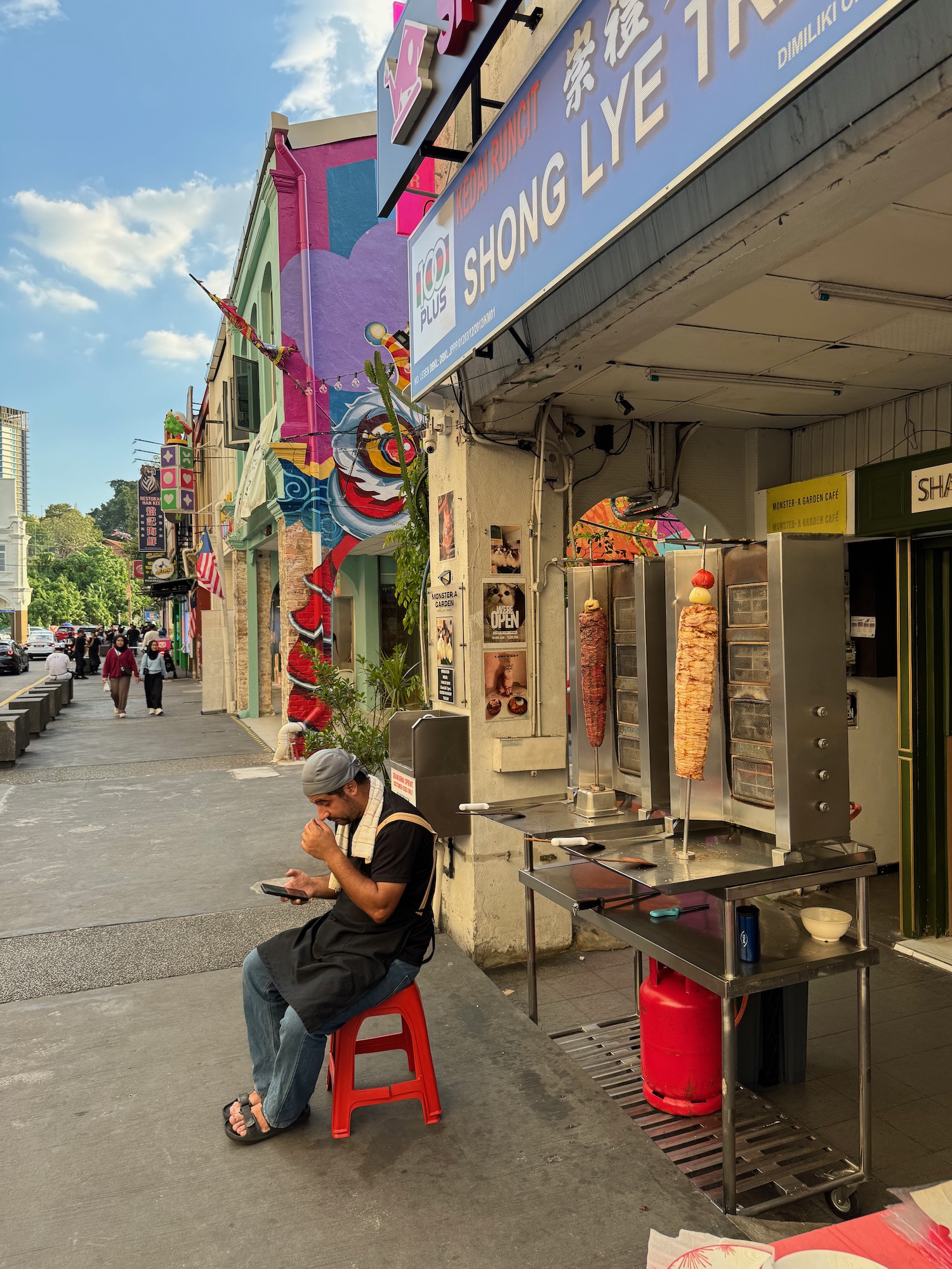 a man sitting on a stool outside of a store