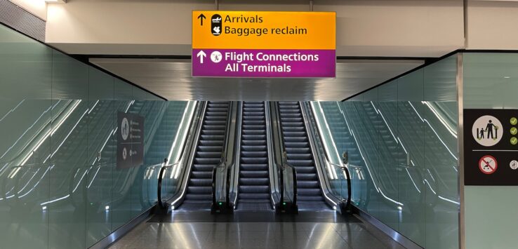 an escalator with an airport sign
