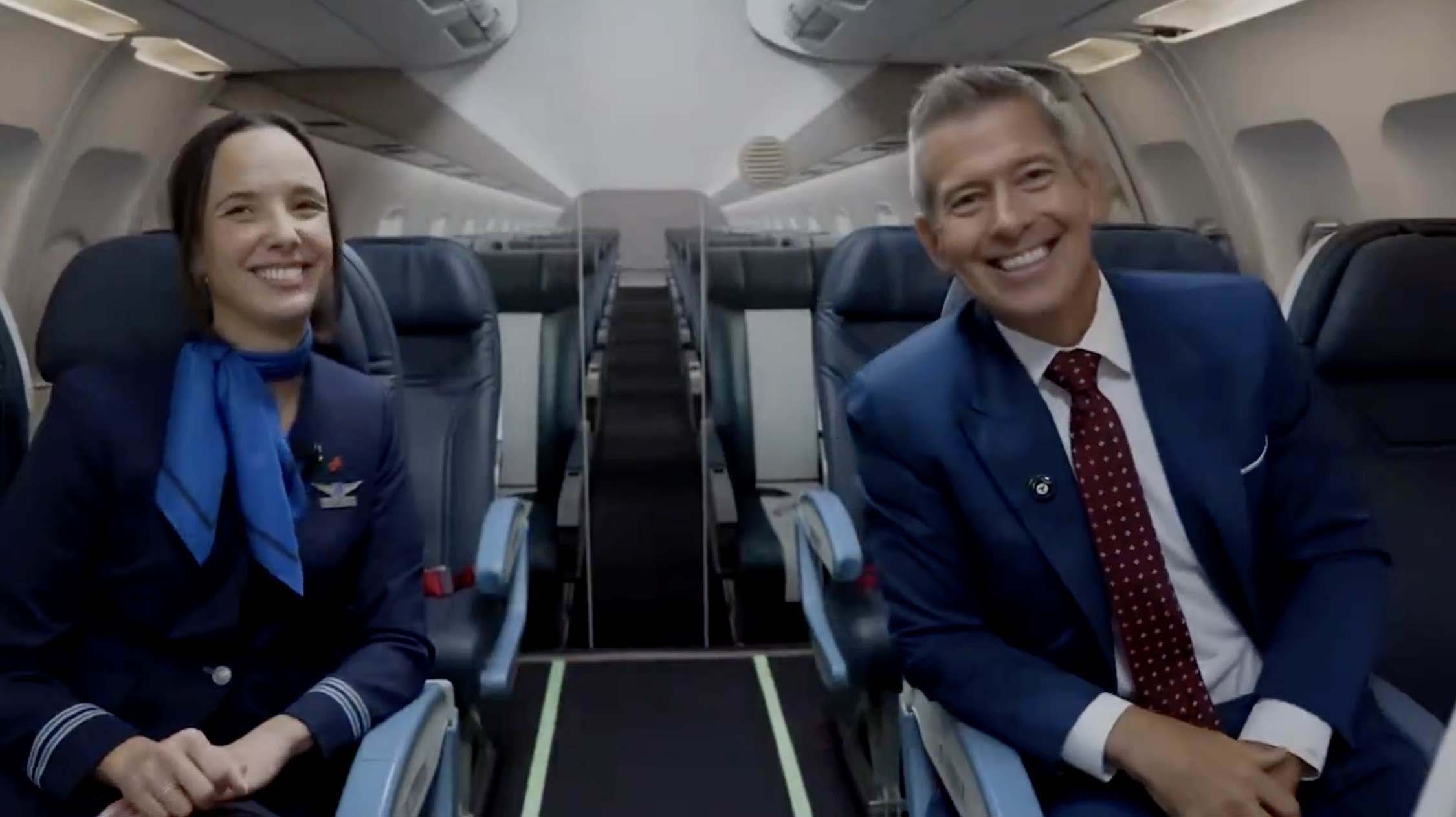 two men in suits sitting in an airplane