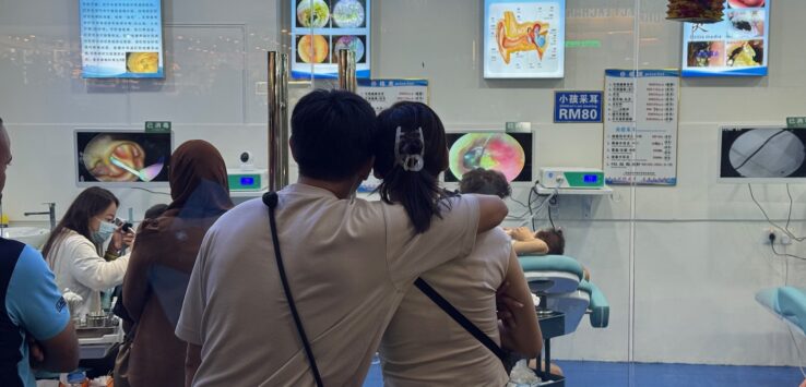 a man and woman standing in front of a window