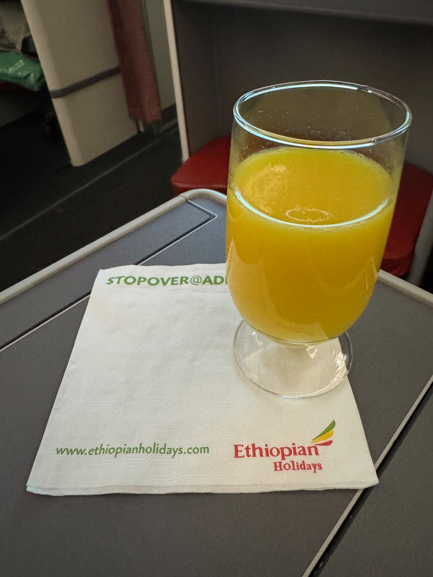 a glass of orange juice on a napkin