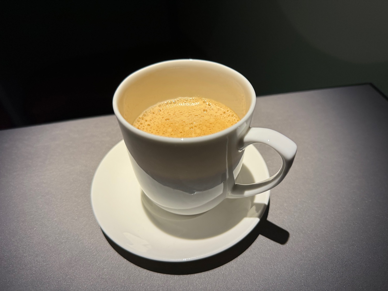 a white cup with a brown liquid in it