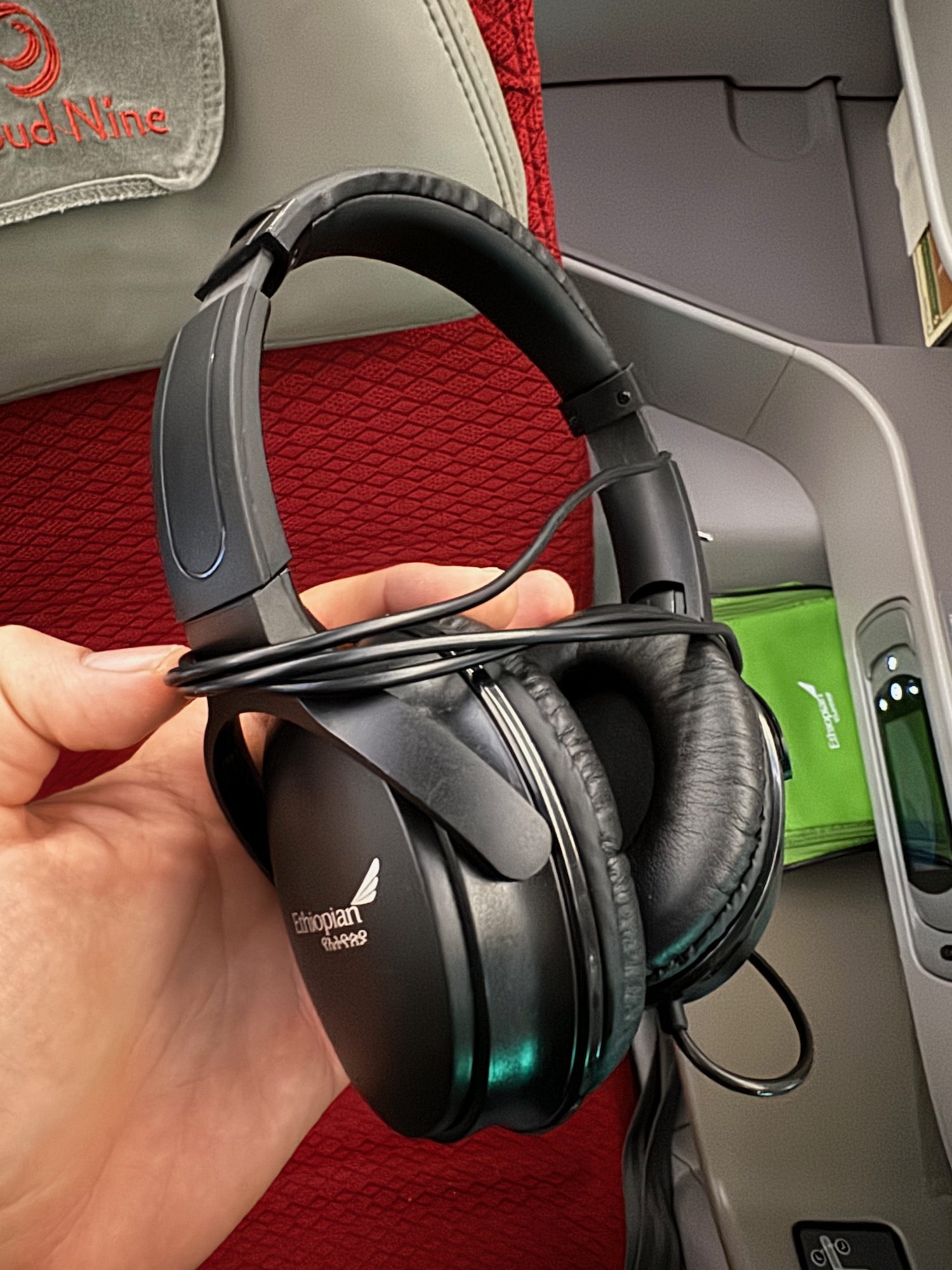 a hand holding a pair of headphones