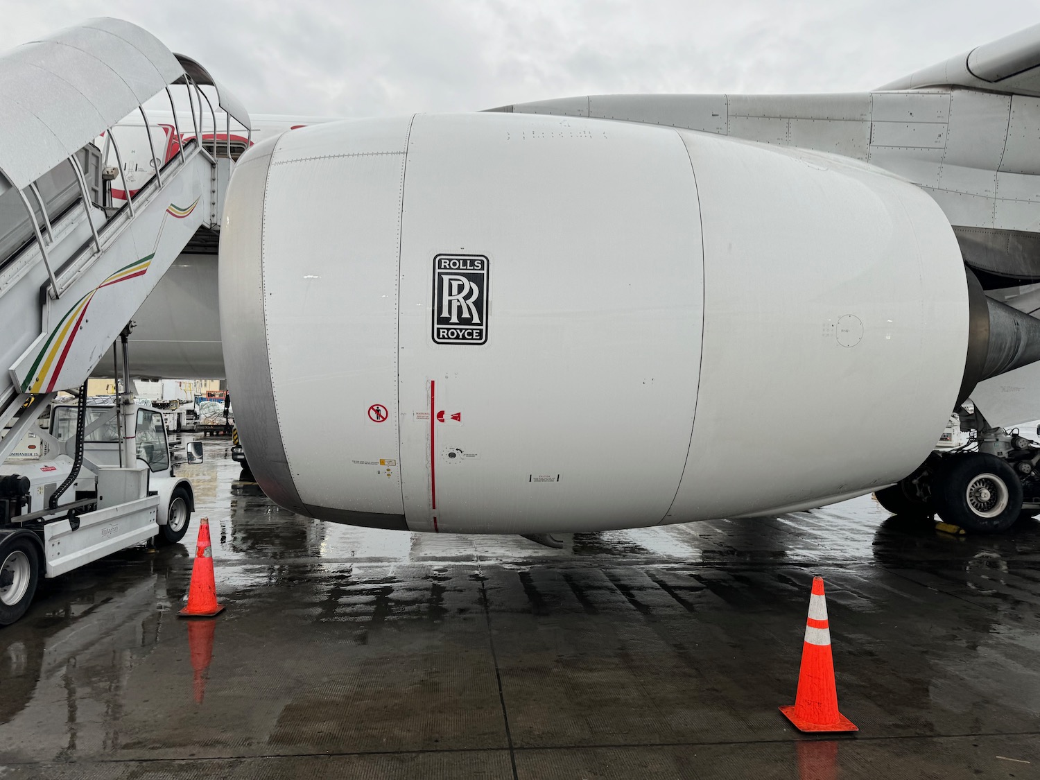 a large white airplane with orange cones