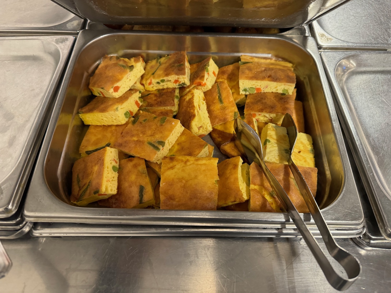 a tray of food with tongs