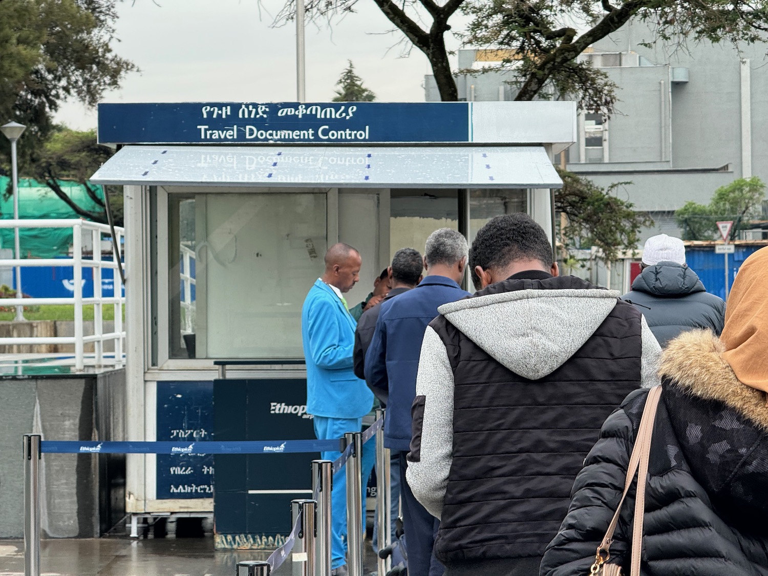 a group of people standing in line at a travel document control booth