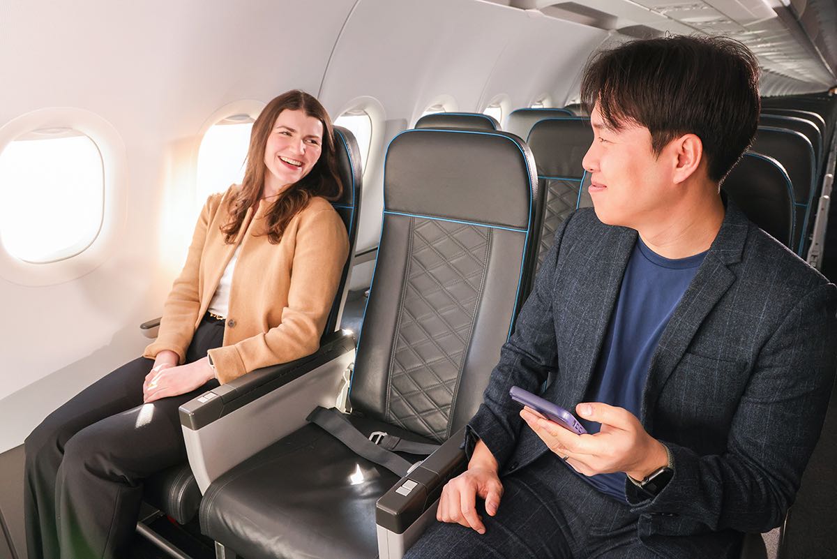 a man and woman sitting in an airplane