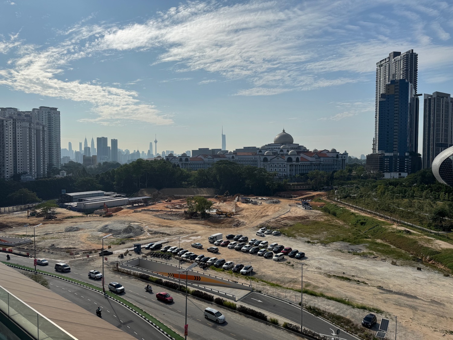 a road with cars and a large building in the background